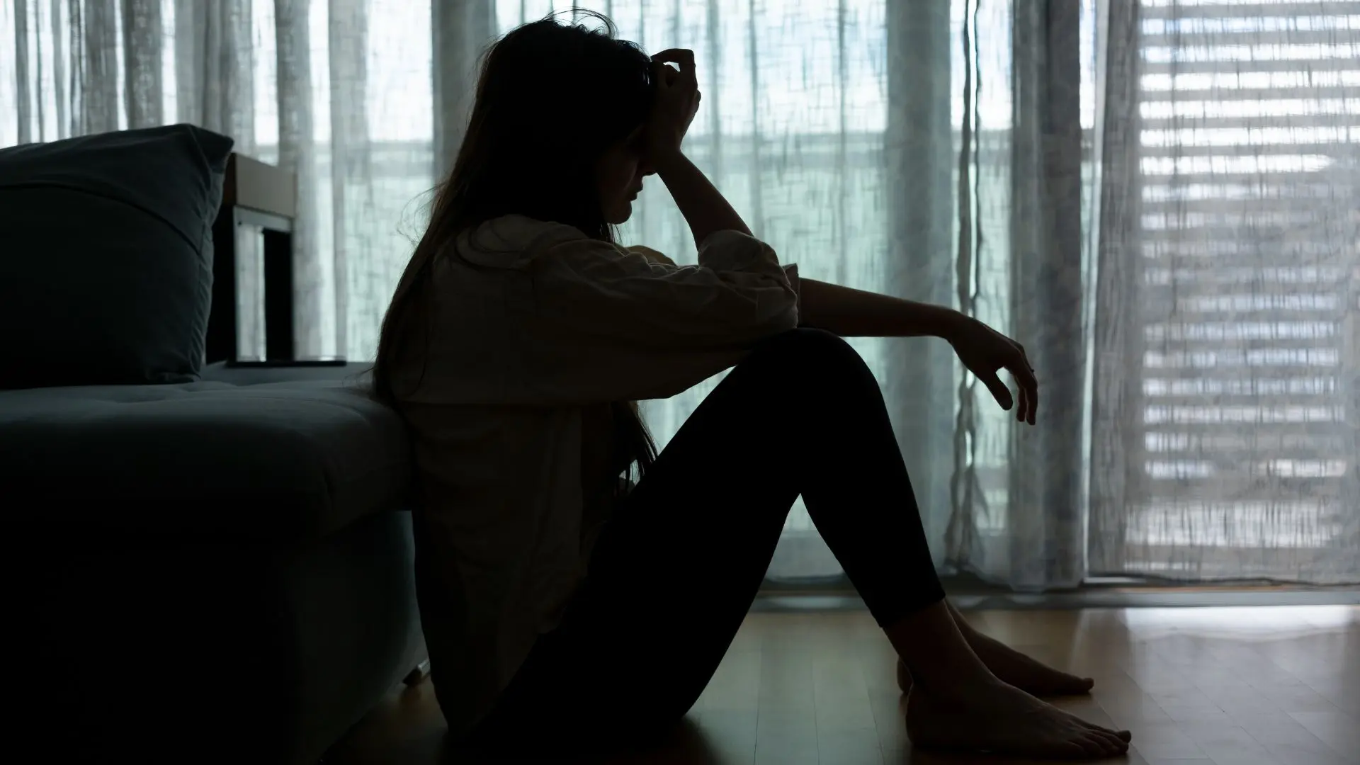 Women looking sad and overwhelmed in an empty room, showing signs of depression
